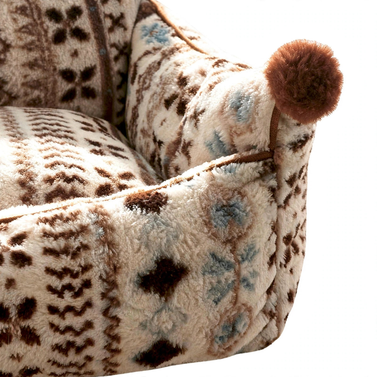 Close-up of bolster pet bed patterned fabric and pom-pom corner
