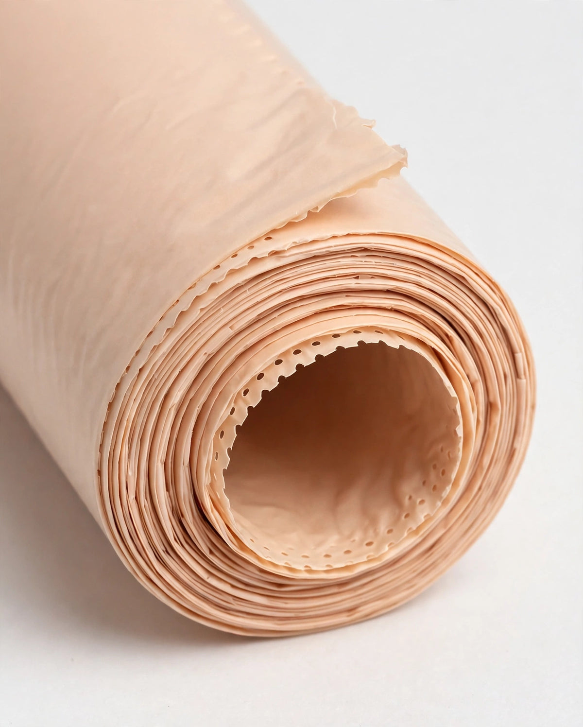 Close-up of beige biodegradable poop bag roll showing perforated tear-off edge
