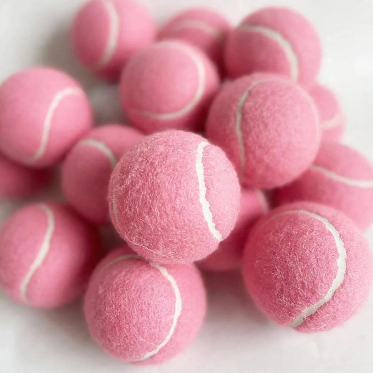 Close-up of pink squeaky tennis balls showing felt texture and seams