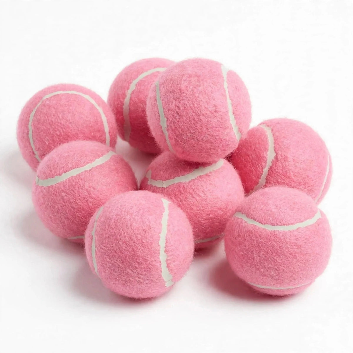 Pink squeaky tennis balls arranged on white background