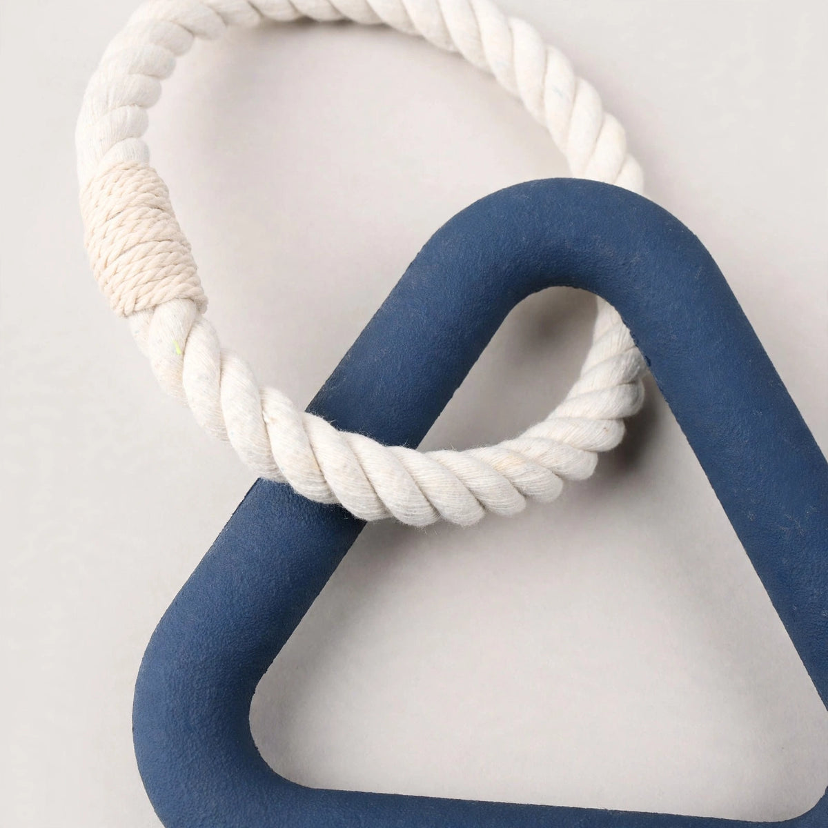 Close-up of navy triangle rubber dog toy and cotton rope